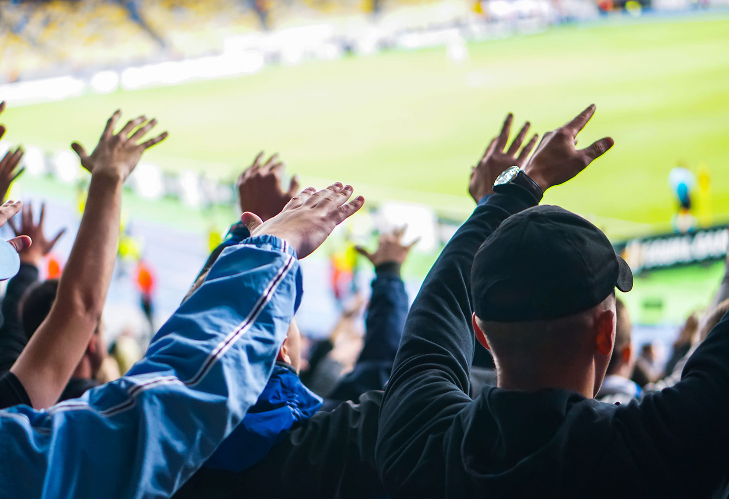 Sports fans doing the wave at a football game.