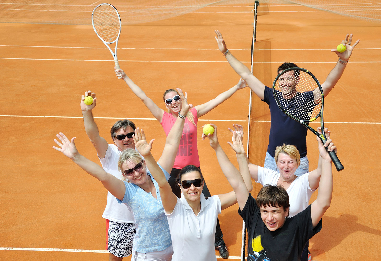 A group of amateur tennis players celebrating a good game.